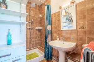 a bathroom with a sink and a shower at Maison Vacances Mer in Bages +16 photos