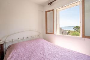 a bedroom with a bed and a window at Maison Vacances Mer in Bages