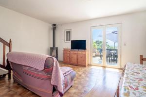a living room with a couch and a tv at Maison Vacances Mer in Bages