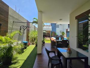 an outdoor patio with tables and chairs and plants at Tourist House in Santa Cruz de la Sierra