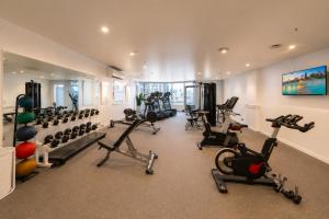 a gym with several treadmills and exercise bikes at Stylish CBD 1BR - Gym & Lounge - Next to Chinatown in Melbourne