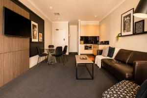 a living room with a couch and a table at Stylish CBD 1BR - Gym & Lounge - Next to Chinatown in Melbourne +7 photos