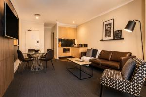 a living room with a couch and a table at Stylish CBD 1BR - Gym & Lounge - Next to Chinatown in Melbourne