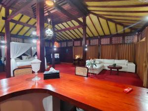 a living room with a table and a couch at The Joglo Sekar Munduk in Pabean Buleleng