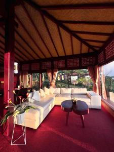 a living room with a white couch and a table at The Joglo Sekar Munduk in Pabean Buleleng