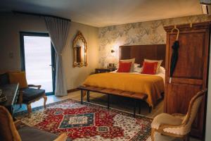 a bedroom with a bed and a table and a chair at The Bohemian Boutique Guesthouse in Tzaneen