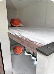 two orange objects are sitting on a bunk bed at Cozy RV tiny home in Fort Lauderdale