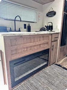 a kitchen with a fireplace in a kitchen with a sink at Cozy RV tiny home in Fort Lauderdale