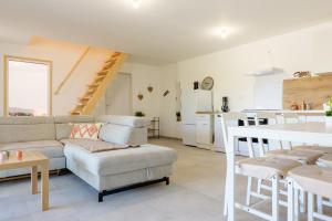 a living room with a couch and a kitchen at Le gecko avec jacuzzi in Saint-Germain +22 photos