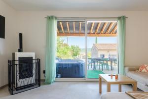 a living room with a large sliding glass door at Le gecko avec jacuzzi in Saint-Germain
