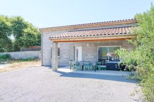 a house with a patio with a table and chairs at Le gecko avec jacuzzi in Saint-Germain