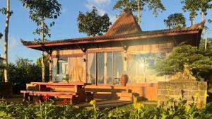 a house with a bench in front of it at The Joglo Sekar Munduk in Pabean Buleleng