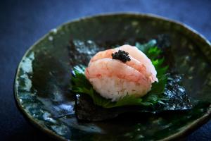 a plate of sushi with shrimp on top of lettuce at Kocho in Kaga