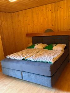 a bed in a room with a wooden wall at Ferienhaus Maximilian, Ideal für Familien in Gamlitz