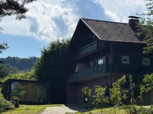 a large black house with a gambrel roof at Ferienhaus Maximilian, Ideal für Familien in Gamlitz