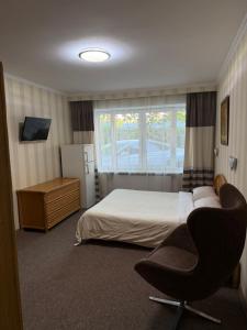 a hotel room with a bed and a chair at For You in Odesa