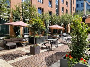 an outdoor patio with tables and chairs and umbrellas at Hilton Munich City in Munich