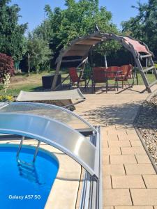 a swimming pool with a gazebo in a yard at Ferienwohnung Bienwald mit Pool für 4 - 6 Personen mit 3 Schlafzimmern in Gröbitz