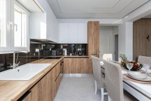 a kitchen with a dining table and a kitchen with white walls at Villa Andrionas Private Pool & Total Privacy in Corfu