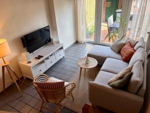 a living room with a couch and a flat screen tv at Dat Lüttje in Fehmarn