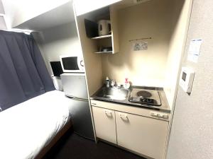 a small kitchen with a sink and a refrigerator at ドリームビレッジエンシン in Kitakami