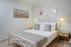 a bedroom with a white bed with white pillows at Althea in Skala Potamias