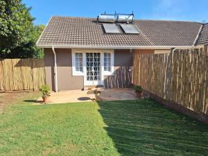 a small house with a fence in a yard at The Pebble in Howick