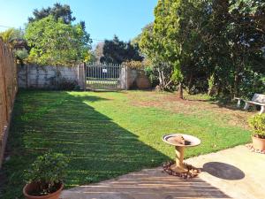 a birdbath in the middle of a yard at The Pebble in Howick +3 photos