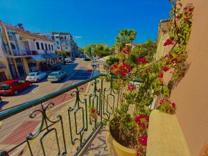a balcony with pink flowers on a city street at TRAVELLERS CORFU TOWN Luxury Suites, Studios & Apartments in Ágios Rókkos