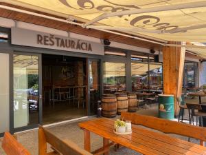 a restaurant with a wooden bench and tables and chairs at Apartio Bella in Vysoké Tatry