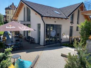 a patio with an umbrella and tables and chairs at Apartio Bella in Vysoké Tatry