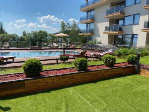 a backyard with a swimming pool and a building at Apartio Bella in Vysoké Tatry +30 photos