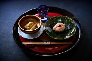 a plate of food with sushi and chopsticks on a table at Kocho in Kaga