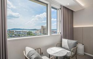 a room with a large window and a table and chairs at Ehan Hotel in Mokpo
