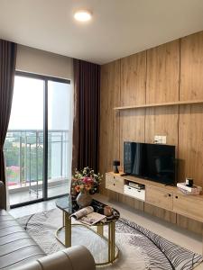 a living room with a couch and a tv at HongHome Compass One in Ga Phú Văn