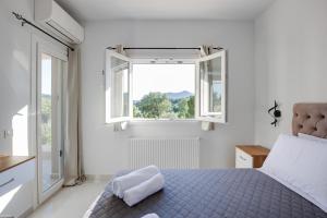 a bedroom with a blue bed and two windows at Villa Andrionas Private Pool & Total Privacy in Corfu +27 photos
