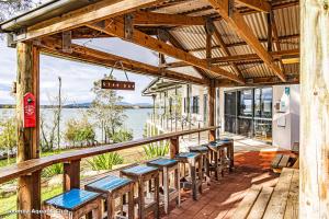 a group of benches on a deck with a view of the water at Byadbo in Tuncurry