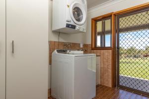 a kitchen with a washing machine and a window at Byadbo in Tuncurry