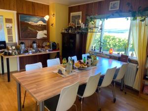 a dining room with a wooden table and white chairs at Öndólfsstaðir Farm B&B in Laugar