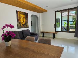 a living room with a table and a couch at Suwaree Garden in Koh Samui