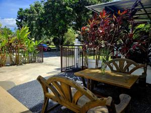 a wooden table and two chairs and a table with flowers at Suwaree Garden in Koh Samui