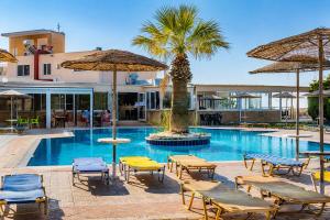 a swimming pool with chairs and umbrellas at Diagoras Hotel All Inclusive in Faliraki