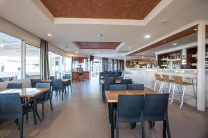 a restaurant with tables and chairs and a bar at Diagoras Hotel All Inclusive in Faliraki