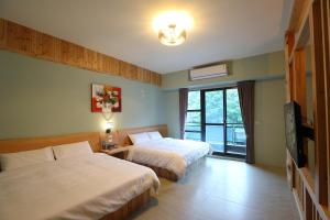 花蓮市にあるHualien Shiado B&Bのベッド2台とテレビがあるホテルの部屋