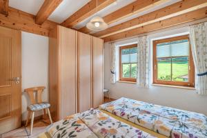 a bedroom with a bed and a chair and a window at Löcherhansenhof in Bad Peterstal-Griesbach