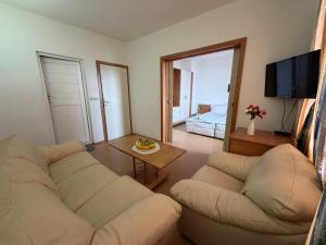 a living room with two white couches and a television at Хотел Черно море in Sveti Vlas +8 photos