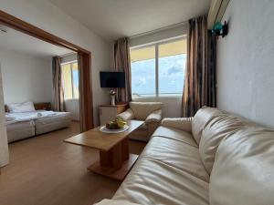a living room with a couch and a table at Хотел Черно море in Sveti Vlas
