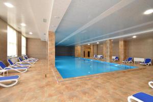 a large swimming pool with chairs around it at Domel Tsaghkadzor in Tsaghkadzor