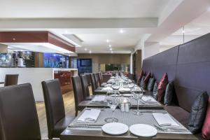 a long dining room with a long table with wine glasses at NH Collection Bogota Andino Royal in Bogotá