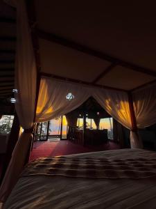 a bed in a room with a canopy at The Joglo Sekar Munduk in Pabean Buleleng